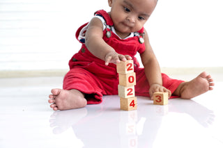 Little kid playing with wooden stacking blocks